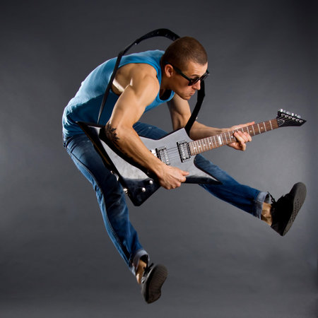 Awesome guitar player jumps with passion in studio 