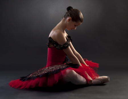 Beautiful ballerina wearing a red tutu on black backgroundの写真素材