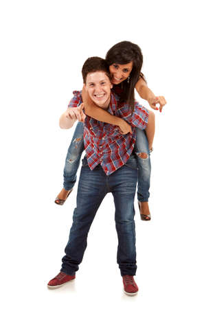 Young man carrying his cute girl on back, and pointing to youの写真素材