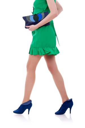 Sexy long legs of fashion model in short dress walking with a purse in her handsの写真素材