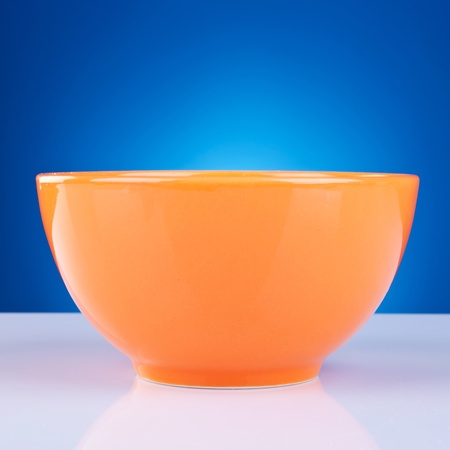 picture of an orange bowl against blue backgroundの写真素材