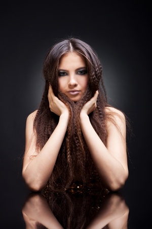 glamour portrait of beautiful  girl and her reflection in mirror table on dark の写真素材
