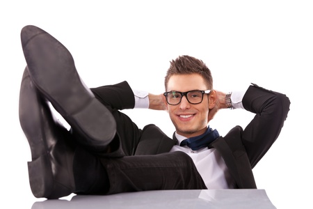 Successful business man relaxing over his desk, isolated in white background の写真素材