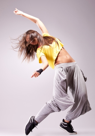 beautiful woman dancer in a passionate dance pose on gray backgroundの写真素材