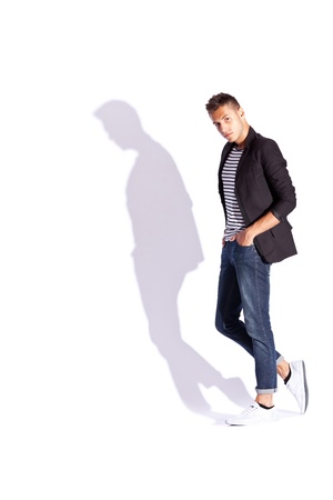 young fashion male model posing on a white background with hard shadowの写真素材