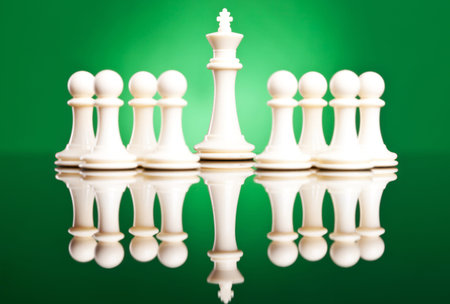 white pawns protecting their leader, the white king - chess pieces on green background