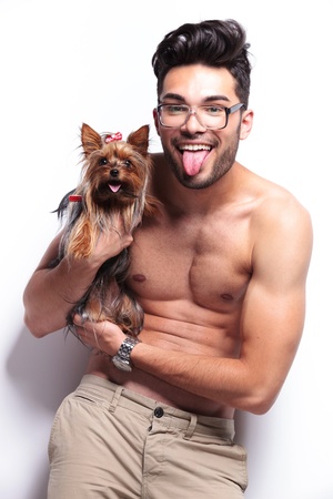 topless young man panting together with a yorkshire puppy . on white backgroundの写真素材