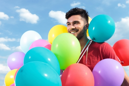 casual man with balloons all over himの写真素材