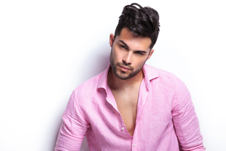 closeup of a young fashion man looking at the camera with a serious look on his face. isolated on a white backgroundの写真素材