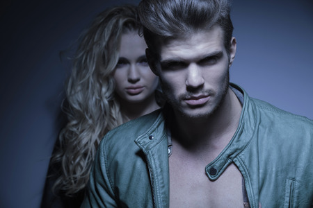 young fashion male model in front of a young yoman, looking at the cameraの写真素材