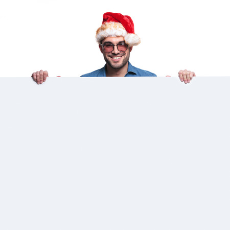 happy santa man is holding and presenting a big blank board on white backgroundの写真素材