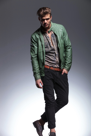 full body picture of a young fashion model posing for the camera on gray studio backgroundの写真素材