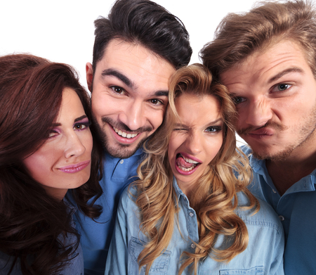 funny wide angle picture of casual people fooling around and making facesの写真素材