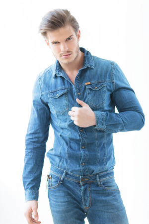 sexy man in jeans casual clothes holding his shirt and smile to the cameraの写真素材