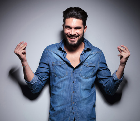 Handsome man in blue shirt smilling and moving his handsの写真素材