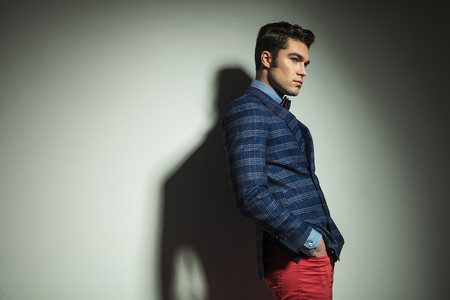 Side view picture of a handsome fashion man standing with his hand in pockets.の写真素材