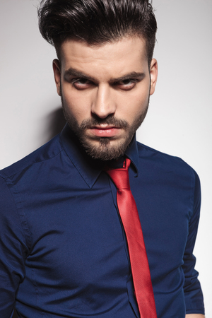Close up picture of a handsome young business man wearing a blue shirt and a red tie.の写真素材