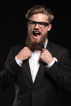 Blond hipster business man screaming while fixing his bow tie.の写真素材