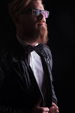 Portrait of a young business man looking up while pulling his jacket.の写真素材