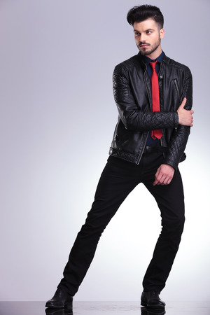 Full length picture of a casual business man posing on grey studio background.の写真素材