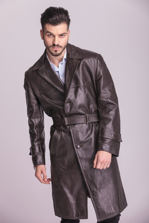 Handsome young business man posing on grey studio background.の写真素材