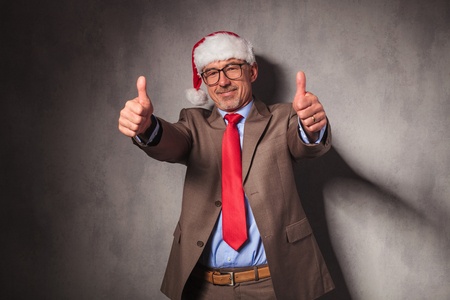 conident santa claus business man making the ok thumbs up hand sign in studioの写真素材