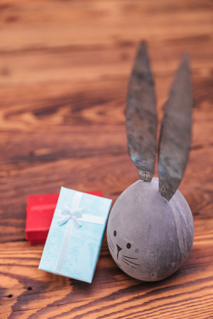 picture from above of easter egg with bunny ears  near presents  on old wood backgroundの写真素材