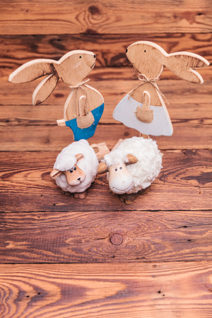wooden easter bunnies and toy sheep all together on old wood backgroundの写真素材