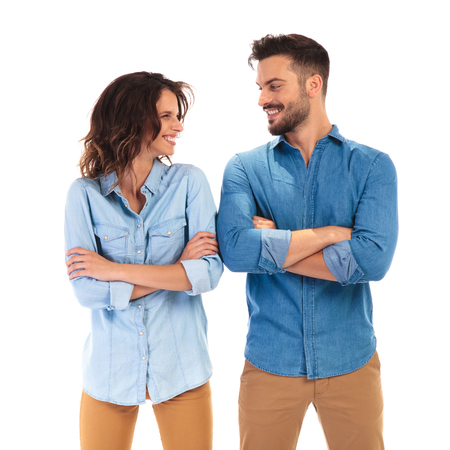 casual man and woman looking at laughing at each other on white backgroundの写真素材