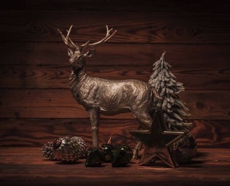 golden reindeer near christmas decorations on old wood backgroundの写真素材