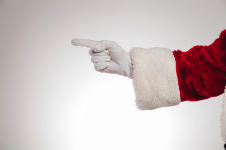 hand of santa claus pointing to side on grey backgroundの写真素材
