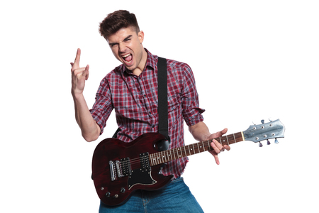 young star making rock on sign while performing on guitar on white background, portrait pictureの写真素材