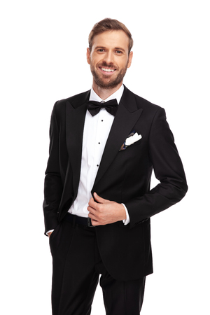 portrait of attractive businessman holding pockets while standing on white backgroundの写真素材