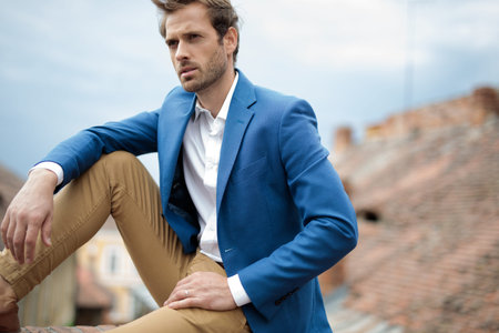 fashion man dreams away while sitting in the cityの写真素材