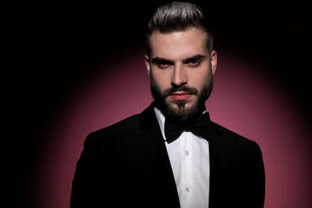 fashion businessman wearing black tuxedo, looking at the camera and being dramaticの写真素材