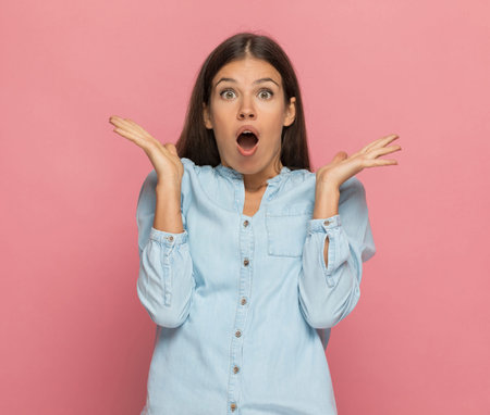 sexy casual woman feeling shocked of what she hears against pink background