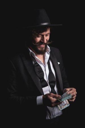 happy businessman is counting his romanian money and wearing a hat on black background