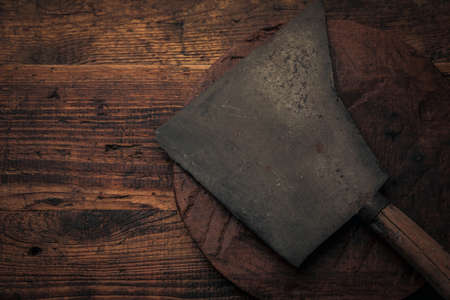 top view of an old big rusty cleaver on a rustic wooden tableの写真素材