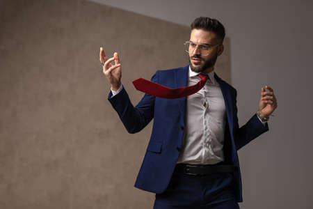 handsome businessman with carefree vibe is posing with his hands up and wearing eyeglassesの写真素材