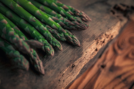 closeup picture of asparagus's tip on top of a old chopping board on wodden table, in a vegan menu