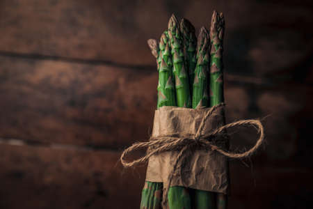 closeup rustic picture of a lovely bunch of fresh sparrow grass wrapped and tied with a ropeの写真素材