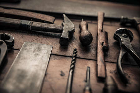close up picture of some carpentry tools on working table, hammer, square, drill, spokeshave, pincers and gouge for a craftsmanship conceptの写真素材