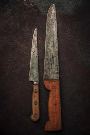 table top of set with 2 carbons steel knives, kitchen knife and small utility knife on top of rusty...