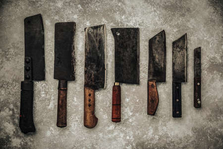 table top picture of kitchen equipment on top of metallic background : meat cleavers with sharp blade and wooden handleの写真素材