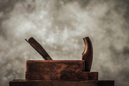 picture of vintage wooden planer on top of old rustic wooden workbench in front of light texture backgroundの写真素材