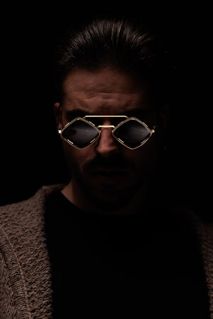 Portrait of attractive guy posing with a mad and tough face, standing, in a fashion poseの写真素材