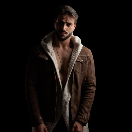 nacked young man wearing wool cardigan and jacket posing in a cool way while looking forward in...