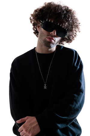 portrait of sexy young man with curly hair wearing cool sunglasses, holding hands in fashion pose and posing on white backgroundの写真素材