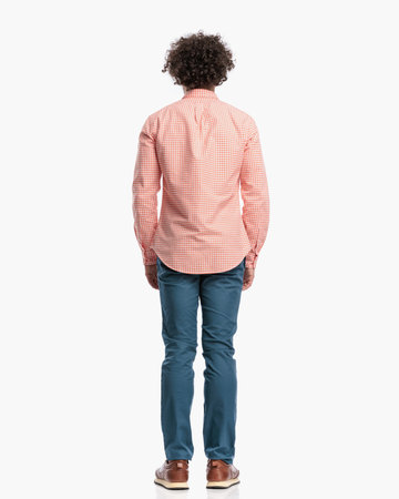 behind view of smart casual guy with curly hair standing in front of white background in studioの写真素材