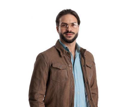 handsome casual man with glasses wearing brown jacket and smiling in front of white background in studioの写真素材
